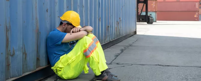 a tired truck driver sitting on the ground