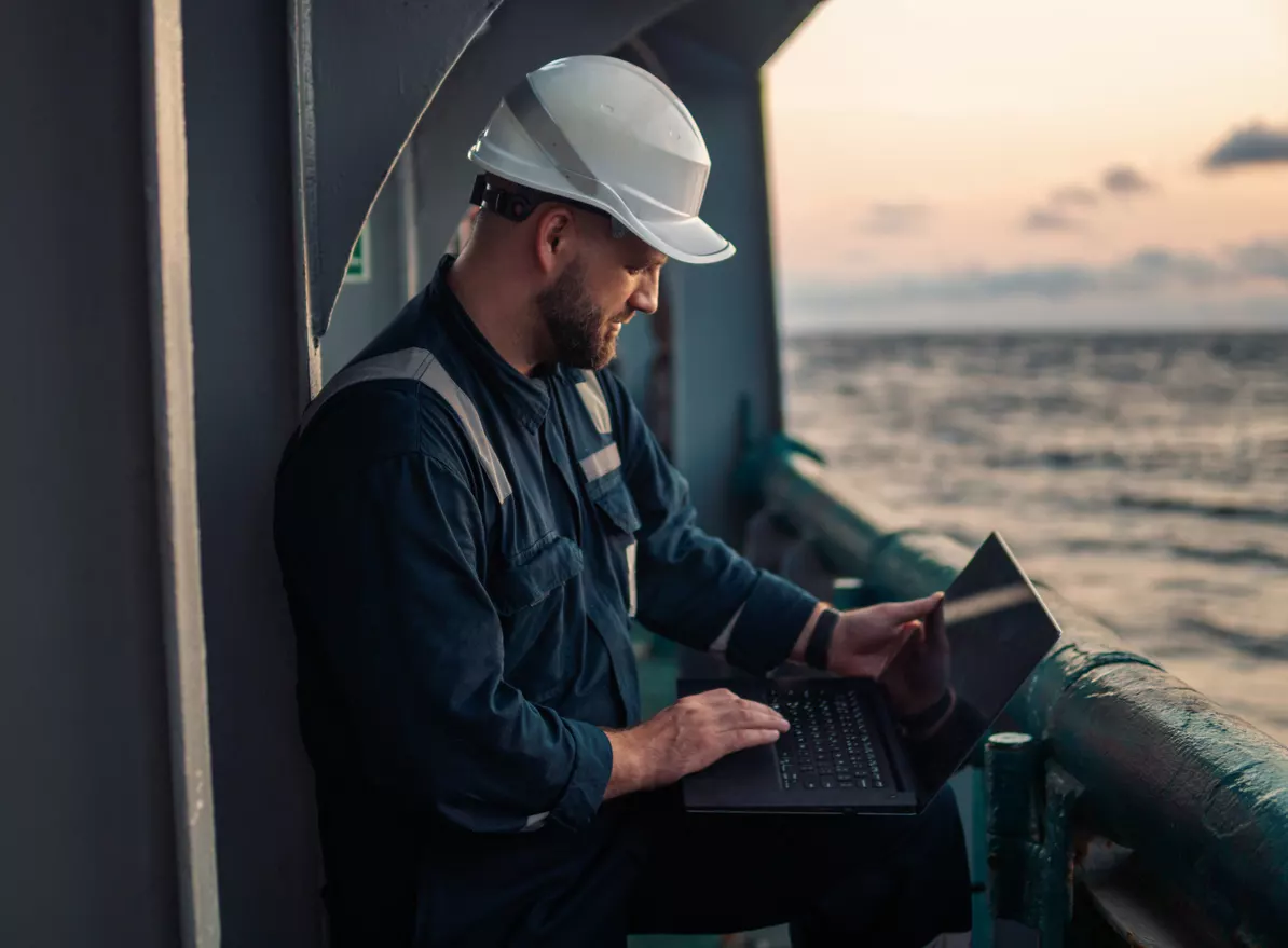 A maritime worker using a laptop to look up a Mississippi River accident lawyer.