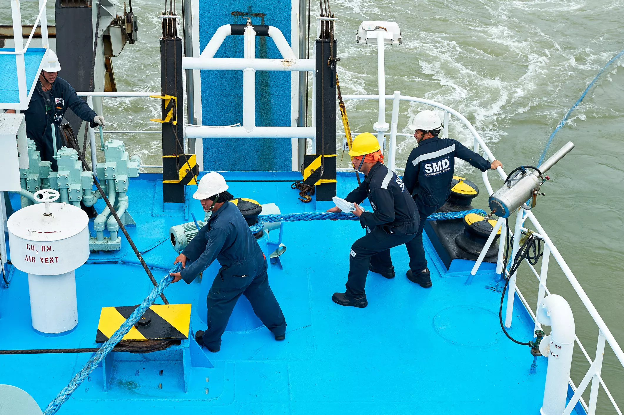 Group of male maritime workers on a ship’s outside deck - consulting with maritime injury lawyers for accidents.