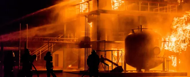 firefighters using water hose to extinguish fire