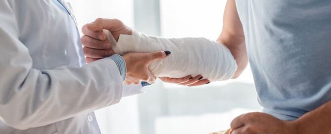 Doctor treats injured worker's arm