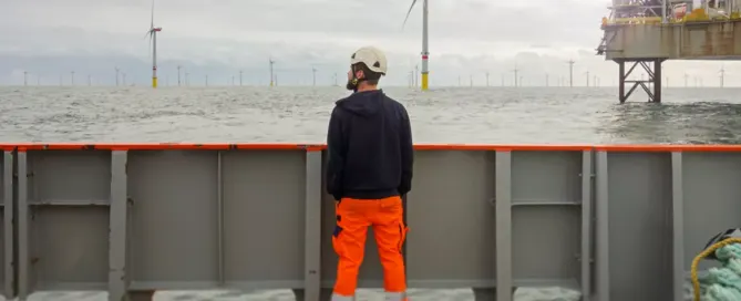 Male maritime worker wearing protective equipment while working at sea.