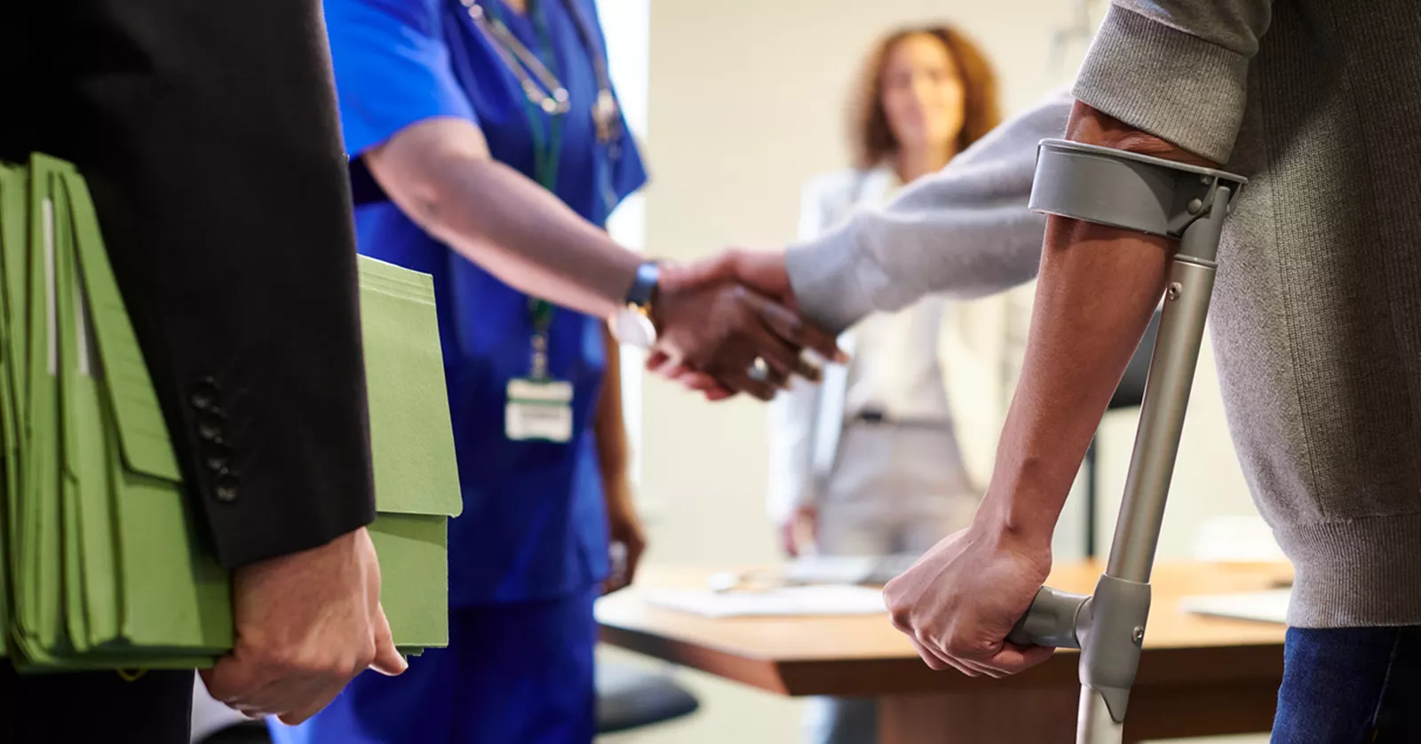 Injured man shaking hands with a medical professional - assistance for catastrophic injuries.