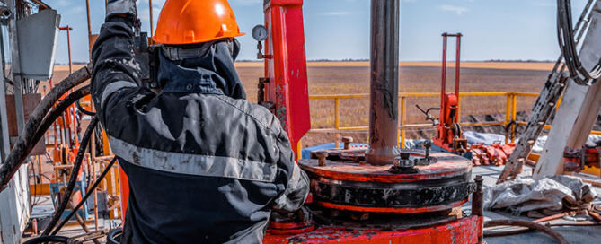 Work driller uses a hydraulic wrench to screw drill pipes to lower them into an oil well and continue drilling it.