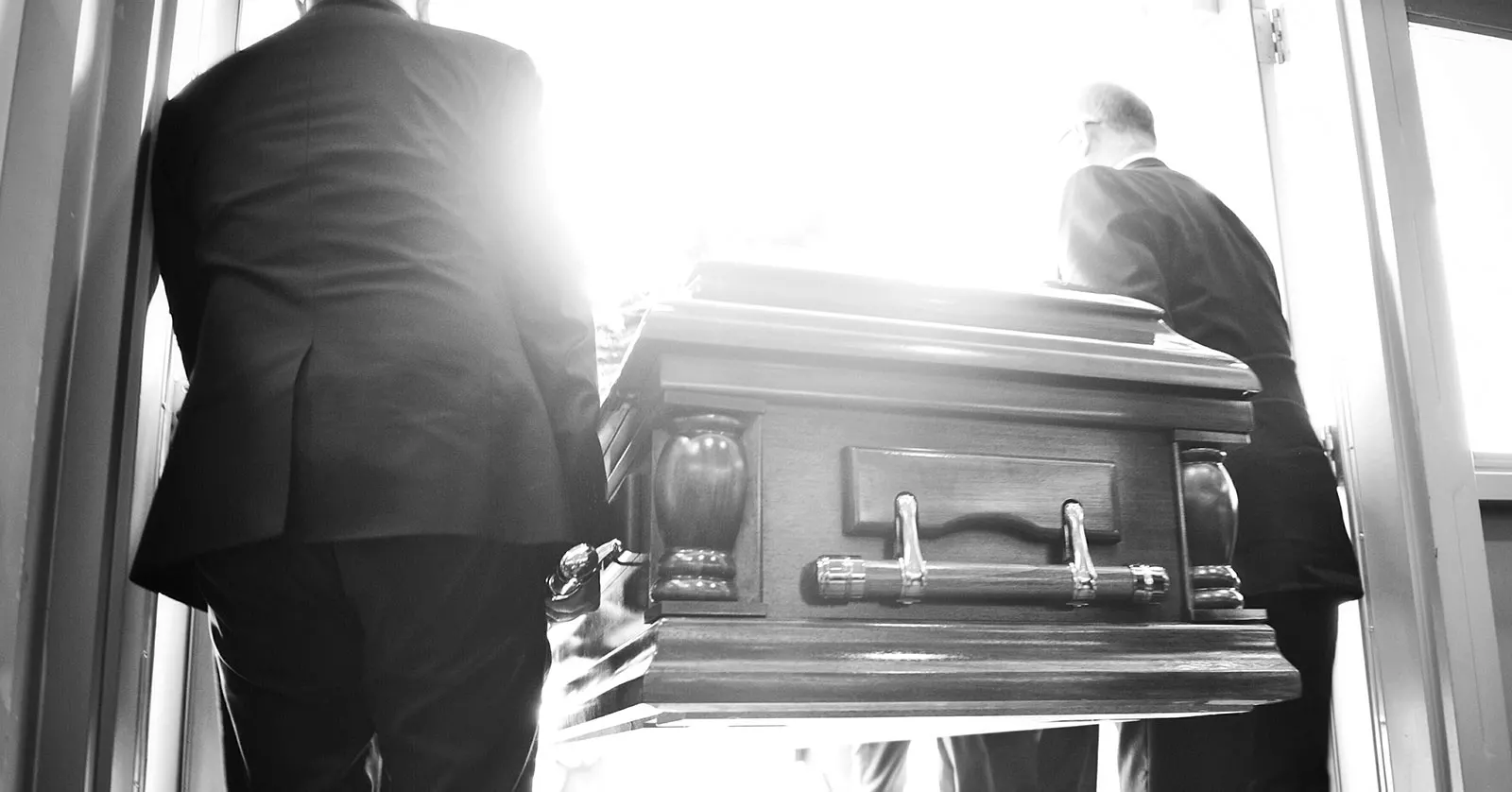 two men are carrying a casket